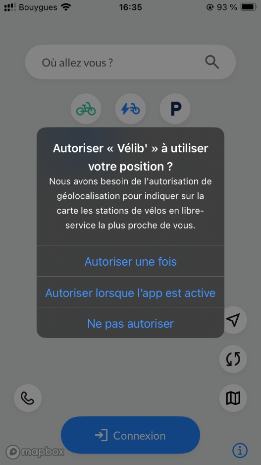 Capture d’écran de l’application Vélib' avec une interface mobile. Une boîte de dialogue en surimpression indique : « Autoriser « Vélib' » à utiliser votre position ? Nous avons besoin de l'autorisation de géolocalisation pour indiquer sur la carte les stations de vélos en libre-service la plus proche de vous. »  Cette mention est suivie de trois lignes indiquant : « Autoriser une fois », « Autoriser lorsque l’app est active » et « Ne pas autoriser »